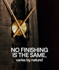 Minimalist wall clock with brass or gold-colored hands mounted on a dark, distressed wooden board, displayed within a wooden frame or shelf.